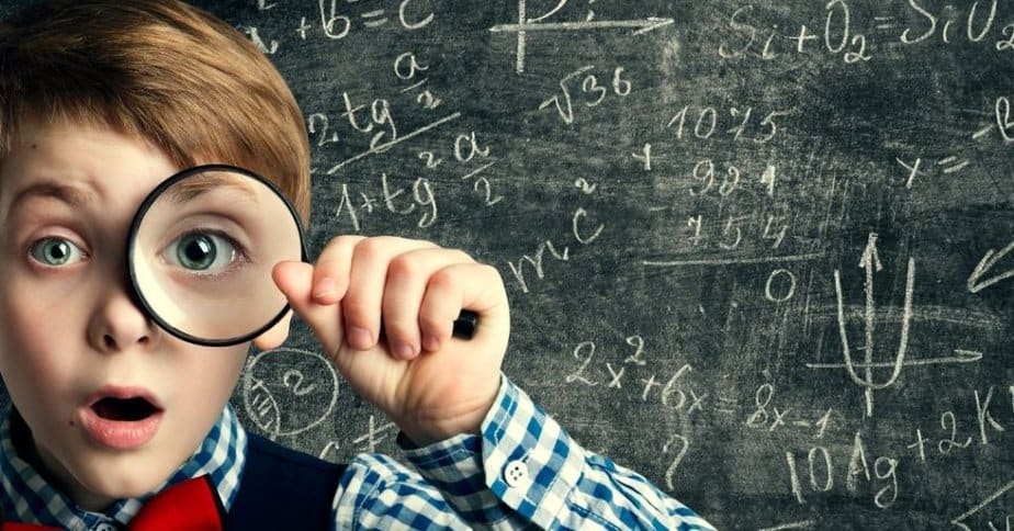 Smart boy looking through magnifying glass with shocked expression to see Bible verses about math