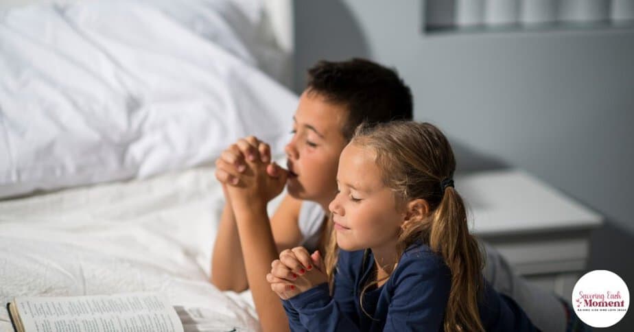 two children kneeling beside their bed praying the Lord's prayer for kids