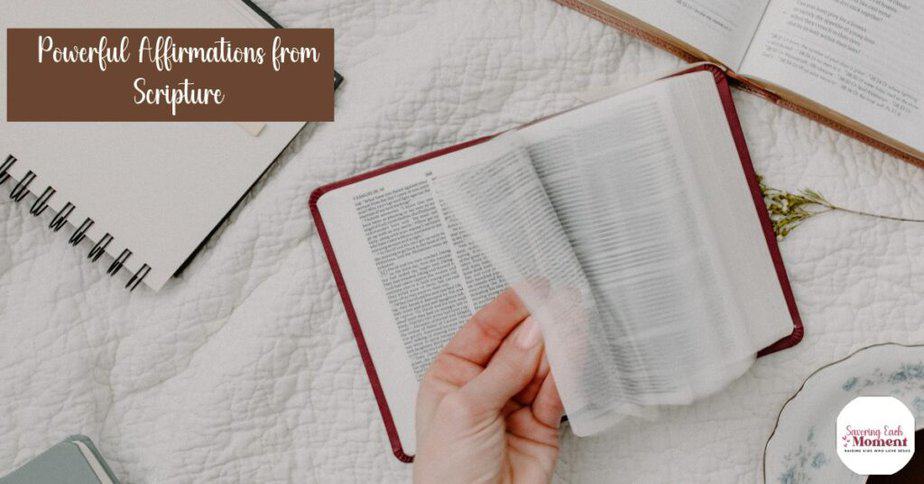 Open Bible with hand turning pages looking for biblical affirmations