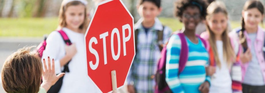 children crossing the road with a stop sign to represent setting boundaries for kids