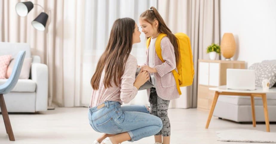 mom praying with her daughter on the first day of school